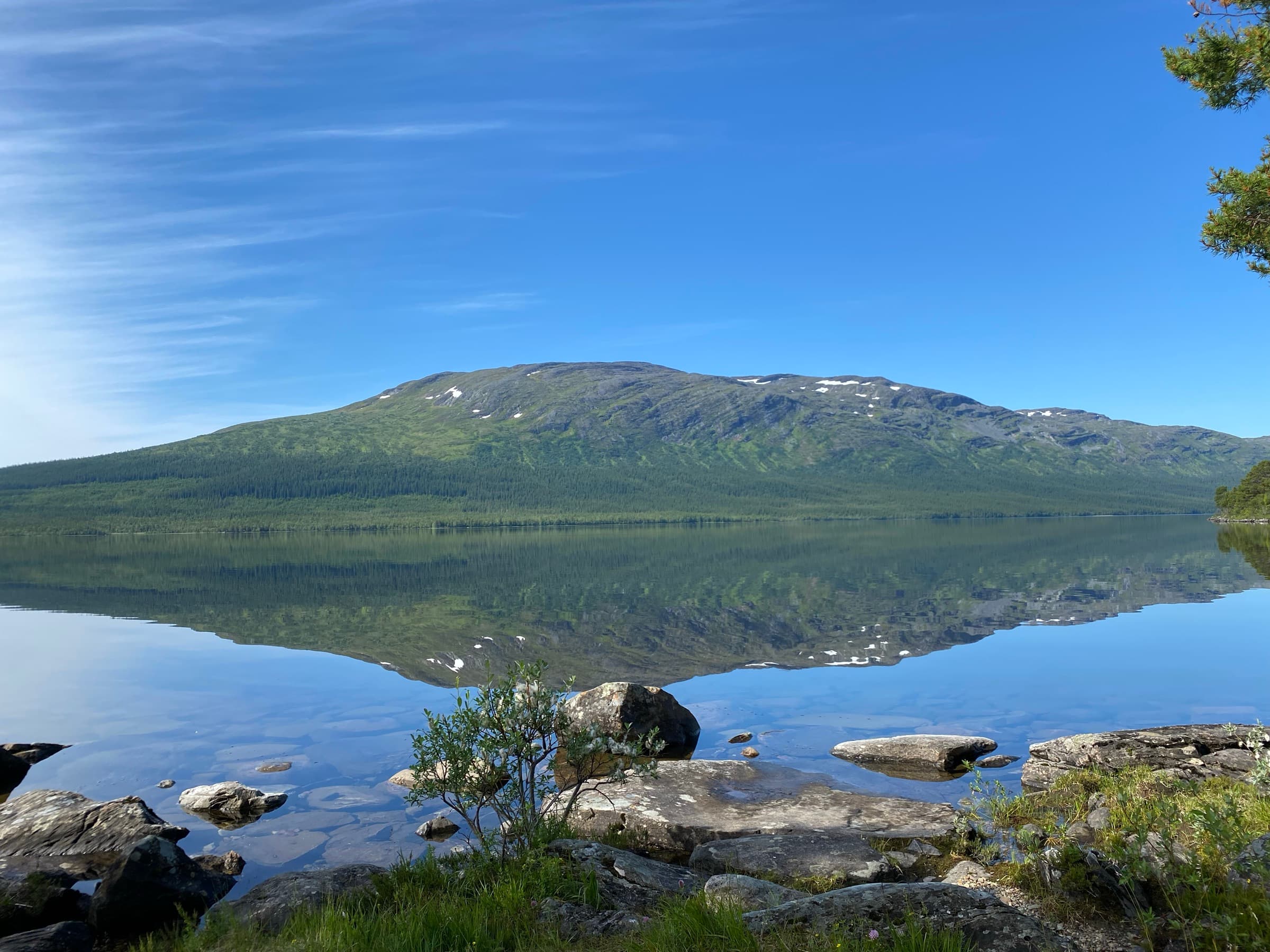 Fjället speglar sig i Ottsjön en vindstilla morgon