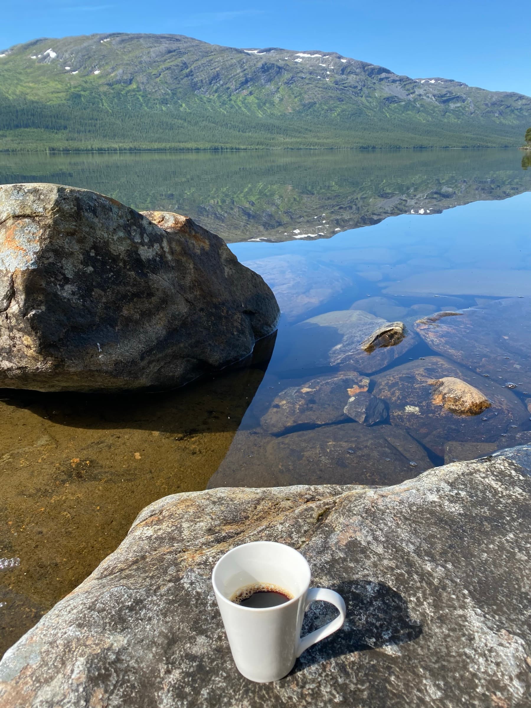 Morgonkaffe på klipporna vid stranden